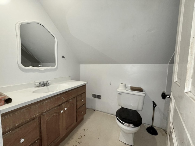 bathroom featuring toilet, vanity, visible vents, and lofted ceiling