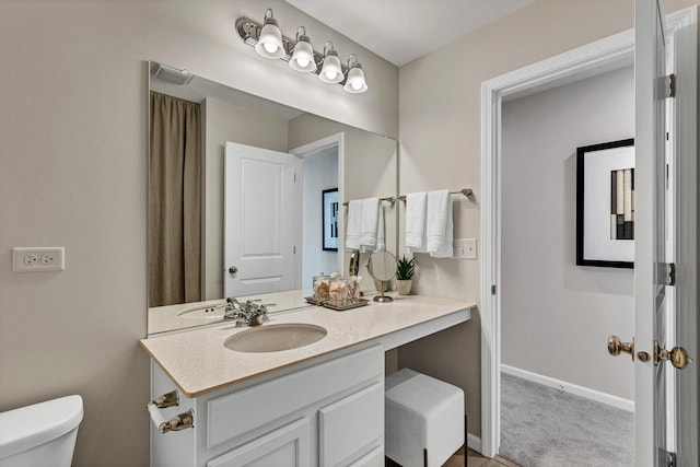 bathroom with toilet, visible vents, baseboards, and vanity