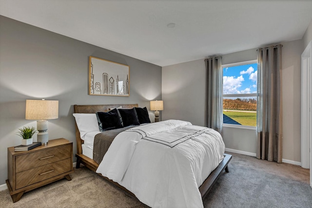 bedroom with baseboards and light colored carpet