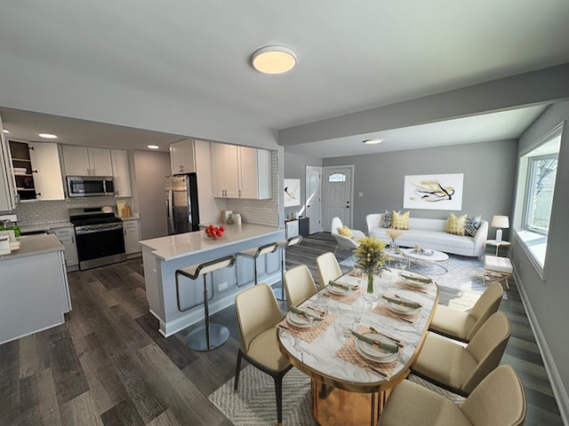 dining area with dark wood-style flooring and baseboards