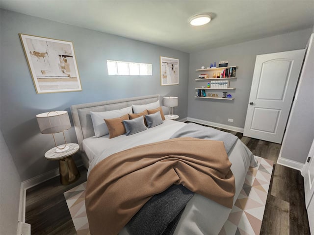 bedroom with baseboards and dark wood-type flooring