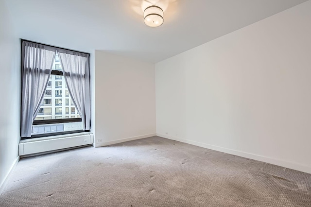 carpeted spare room featuring a baseboard radiator and baseboards