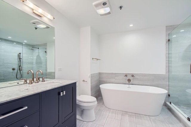 full bathroom featuring a soaking tub, a shower stall, vanity, and tile walls