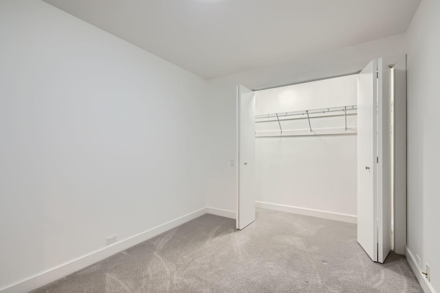 unfurnished bedroom with carpet, baseboards, and a closet