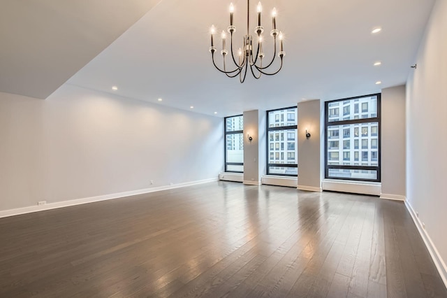 spare room with dark wood-style floors, a chandelier, recessed lighting, and baseboards