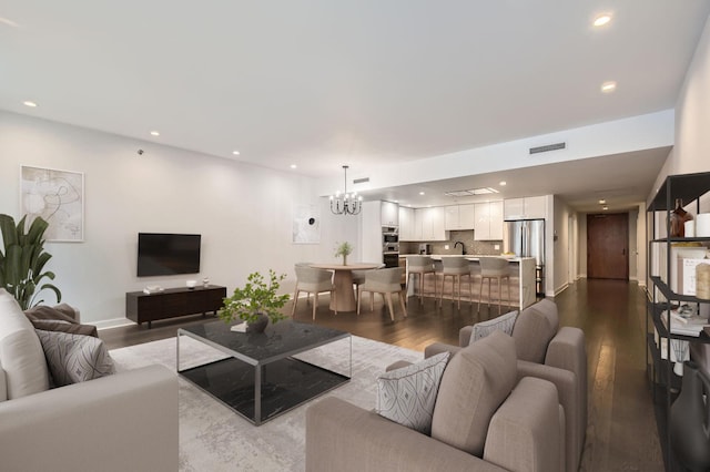 living room with a notable chandelier, recessed lighting, visible vents, and dark wood-style flooring