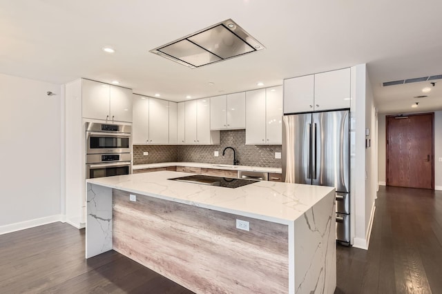 kitchen with a sink, appliances with stainless steel finishes, white cabinetry, modern cabinets, and backsplash