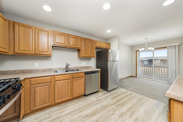 kitchen with stainless steel appliances, light countertops, hanging light fixtures, and a sink