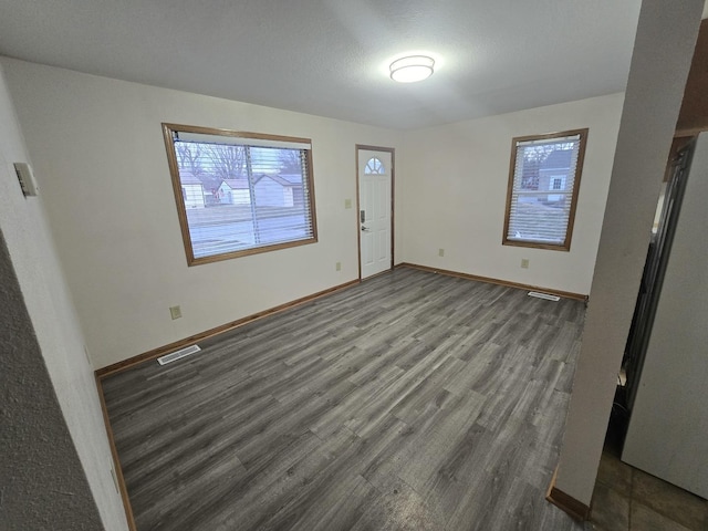 interior space featuring visible vents, baseboards, and wood finished floors