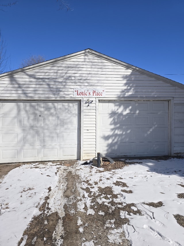 snow covered garage with a garage