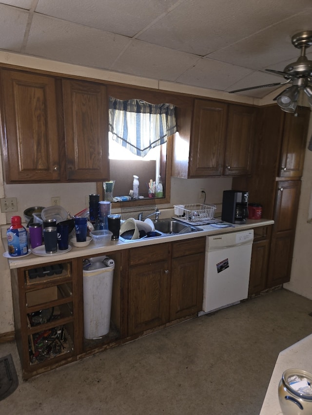 kitchen with a drop ceiling, a sink, a ceiling fan, light countertops, and dishwasher