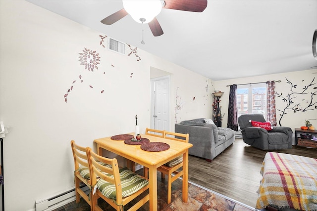 dining space featuring a baseboard heating unit, ceiling fan, wood finished floors, and visible vents