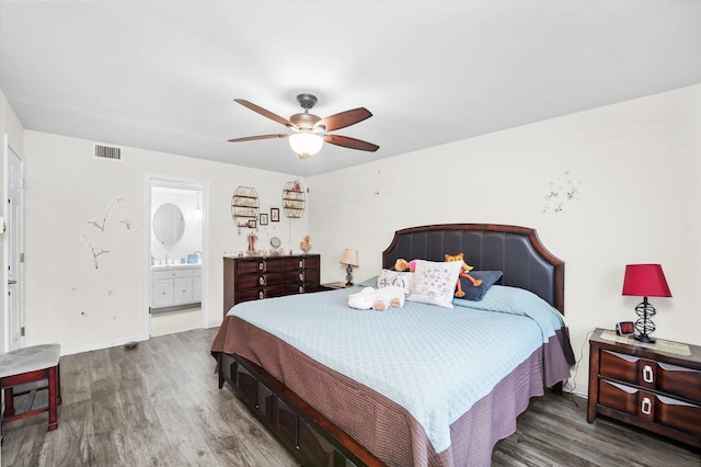 bedroom featuring dark wood-style floors, ensuite bathroom, visible vents, and baseboards