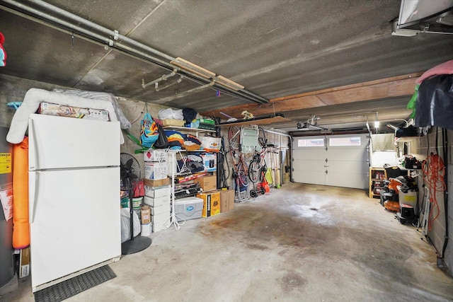 garage featuring a garage door opener and freestanding refrigerator