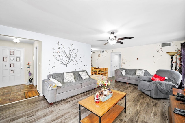 living area with ceiling fan, visible vents, and wood finished floors