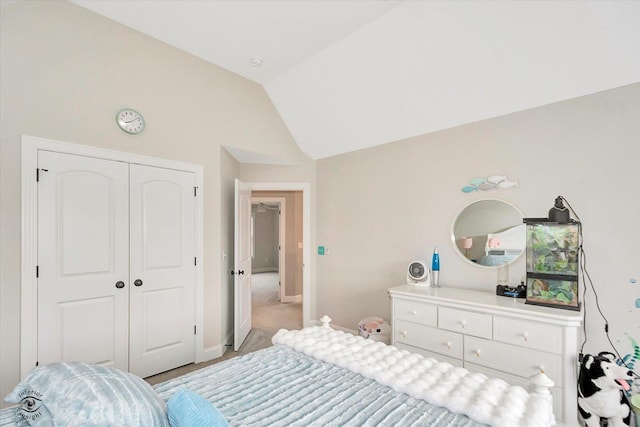 bedroom with vaulted ceiling, a closet, and baseboards