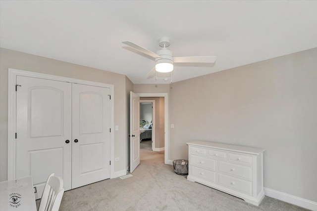 bedroom featuring a closet, light carpet, and baseboards