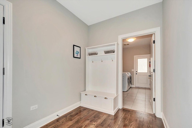 laundry room featuring laundry area, wood finished floors, washing machine and dryer, and baseboards