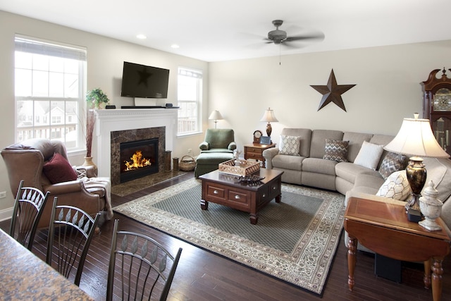 living room featuring a ceiling fan, a high end fireplace, recessed lighting, and wood finished floors