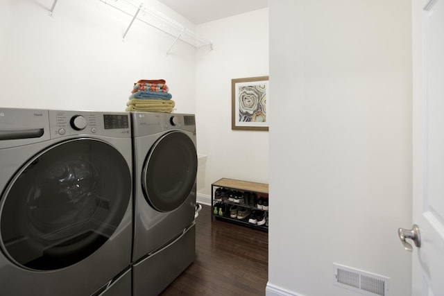 clothes washing area with dark wood-style floors, laundry area, visible vents, and separate washer and dryer