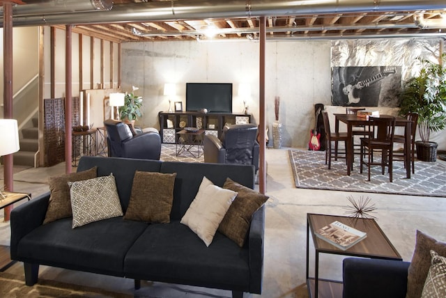 living room featuring concrete floors and stairs