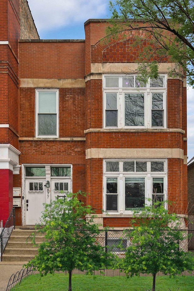 view of front of house with a fenced front yard and brick siding