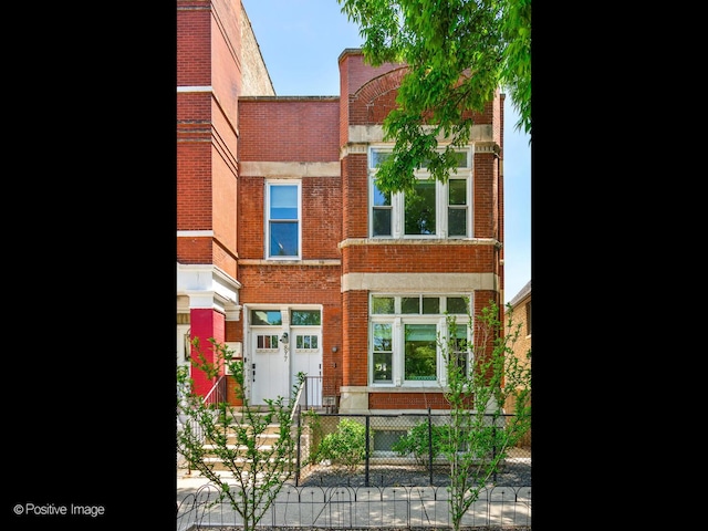 877 N Mozart St, Chicago, IL 60622 - view of front of property featuring brick siding and a fenced front yard
