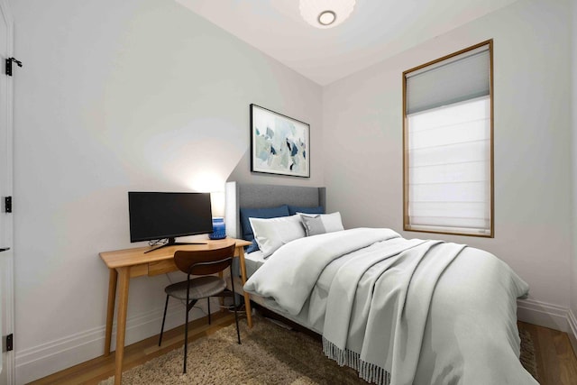 bedroom featuring wood finished floors and baseboards