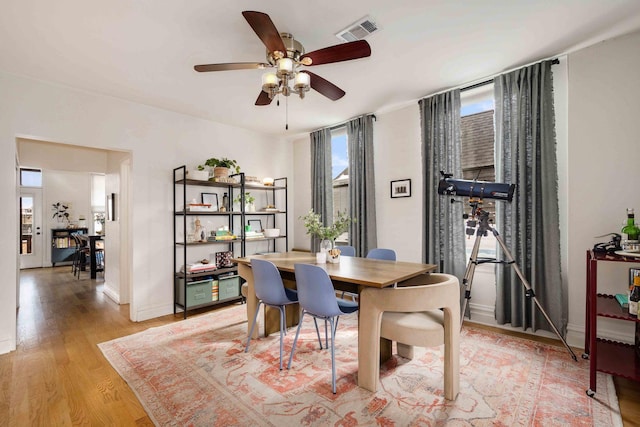 dining room with ceiling fan, light wood-style floors, visible vents, and baseboards