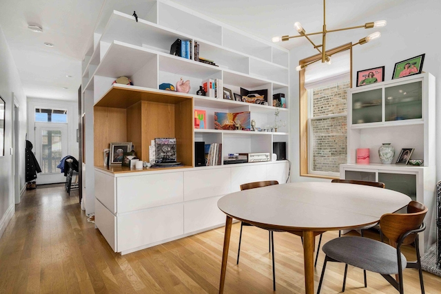 dining area with a notable chandelier and light wood-style flooring