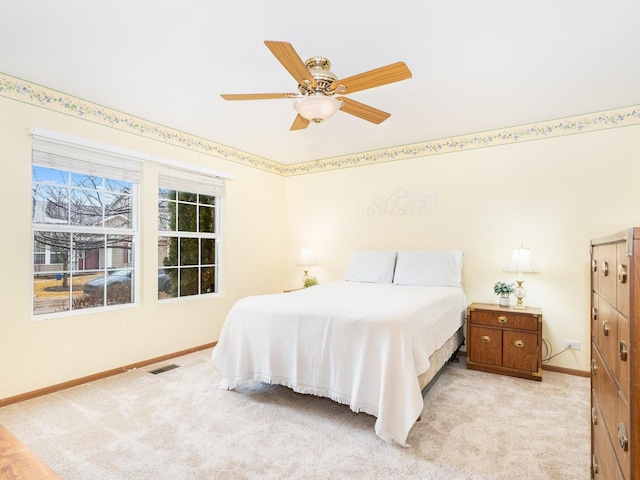 bedroom with baseboards, ceiling fan, visible vents, and light colored carpet