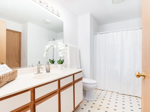 bathroom featuring visible vents, vanity, toilet, and tile patterned floors