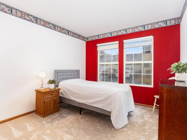 bedroom featuring light carpet and baseboards