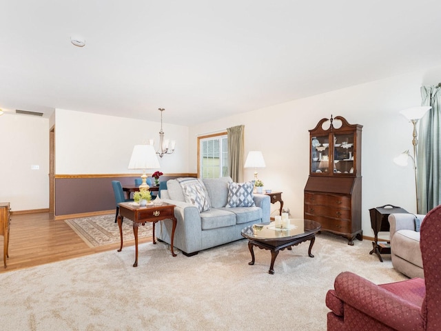 living area with a chandelier, carpet floors, wood finished floors, and visible vents