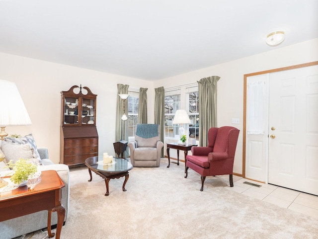 living room with light carpet, visible vents, and light tile patterned flooring