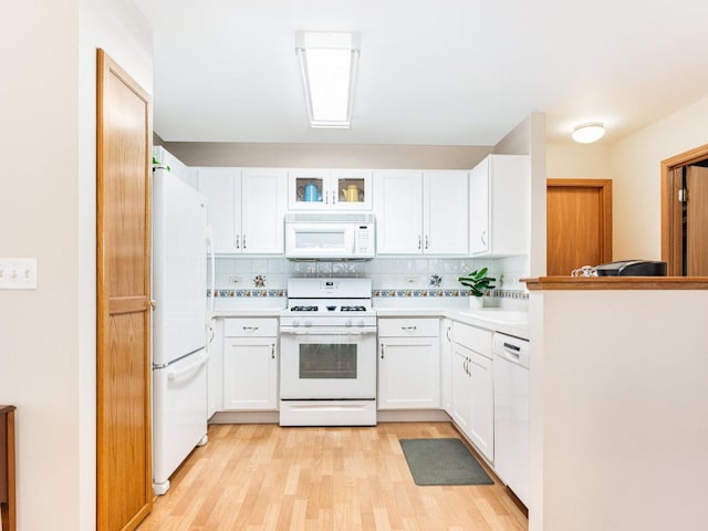 kitchen featuring white cabinets, white appliances, light countertops, and backsplash