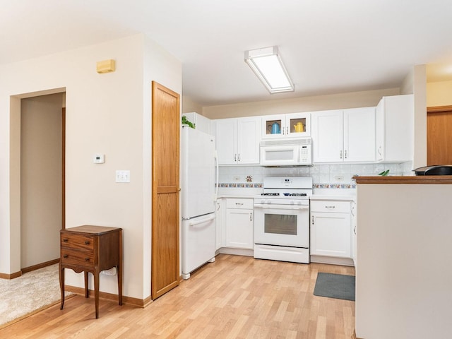 kitchen with white appliances, tasteful backsplash, light wood finished floors, light countertops, and white cabinetry