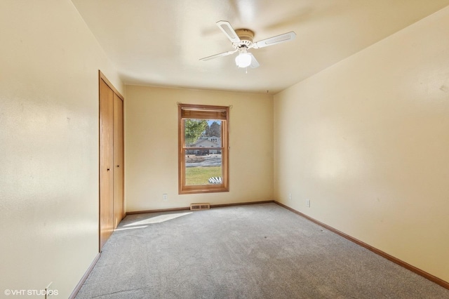 spare room featuring visible vents, baseboards, carpet, and a ceiling fan