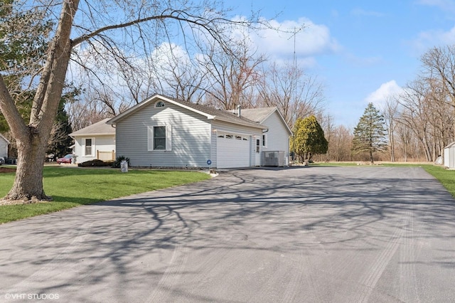 view of property exterior featuring a garage, central AC unit, a lawn, and driveway