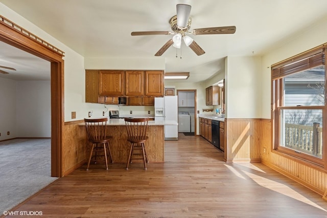 kitchen featuring washer / clothes dryer, white refrigerator with ice dispenser, a ceiling fan, and wainscoting