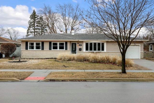 single story home with driveway, a garage, a chimney, and brick siding