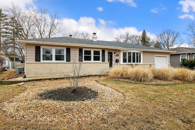 single story home with a garage, a front yard, a chimney, and brick siding