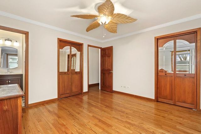 unfurnished bedroom featuring crown molding, baseboards, a sink, and light wood-style floors