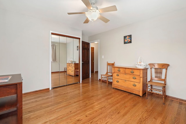 interior space featuring light wood-style floors, a ceiling fan, baseboards, and a closet