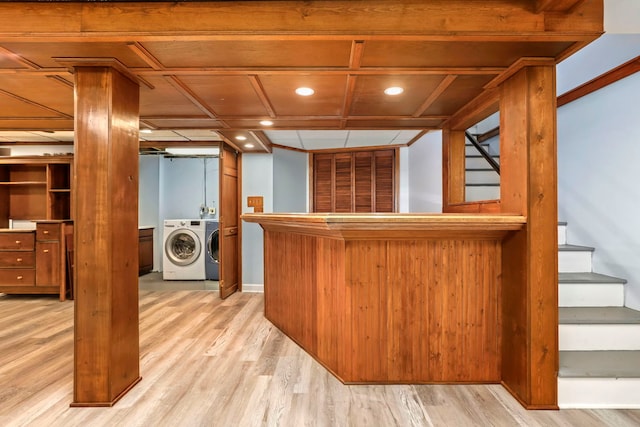 bar with a dry bar, light wood finished floors, washing machine and clothes dryer, stairs, and recessed lighting