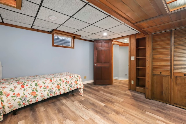 bedroom featuring a closet, baseboards, and wood finished floors