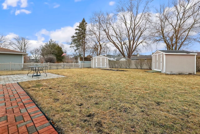 view of yard featuring an outbuilding, a fenced backyard, a patio, and a storage unit