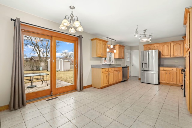 kitchen featuring light tile patterned floors, stainless steel appliances, a sink, visible vents, and pendant lighting