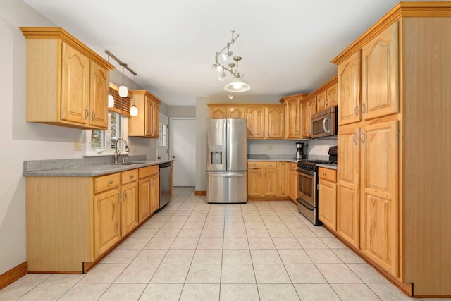 kitchen with light tile patterned floors, a sink, baseboards, appliances with stainless steel finishes, and pendant lighting