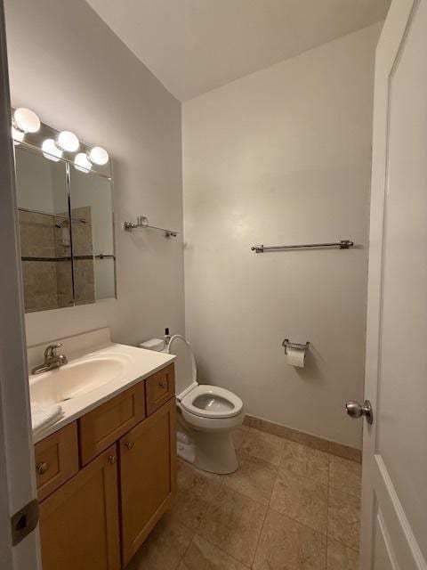 bathroom with baseboards, vanity, and toilet